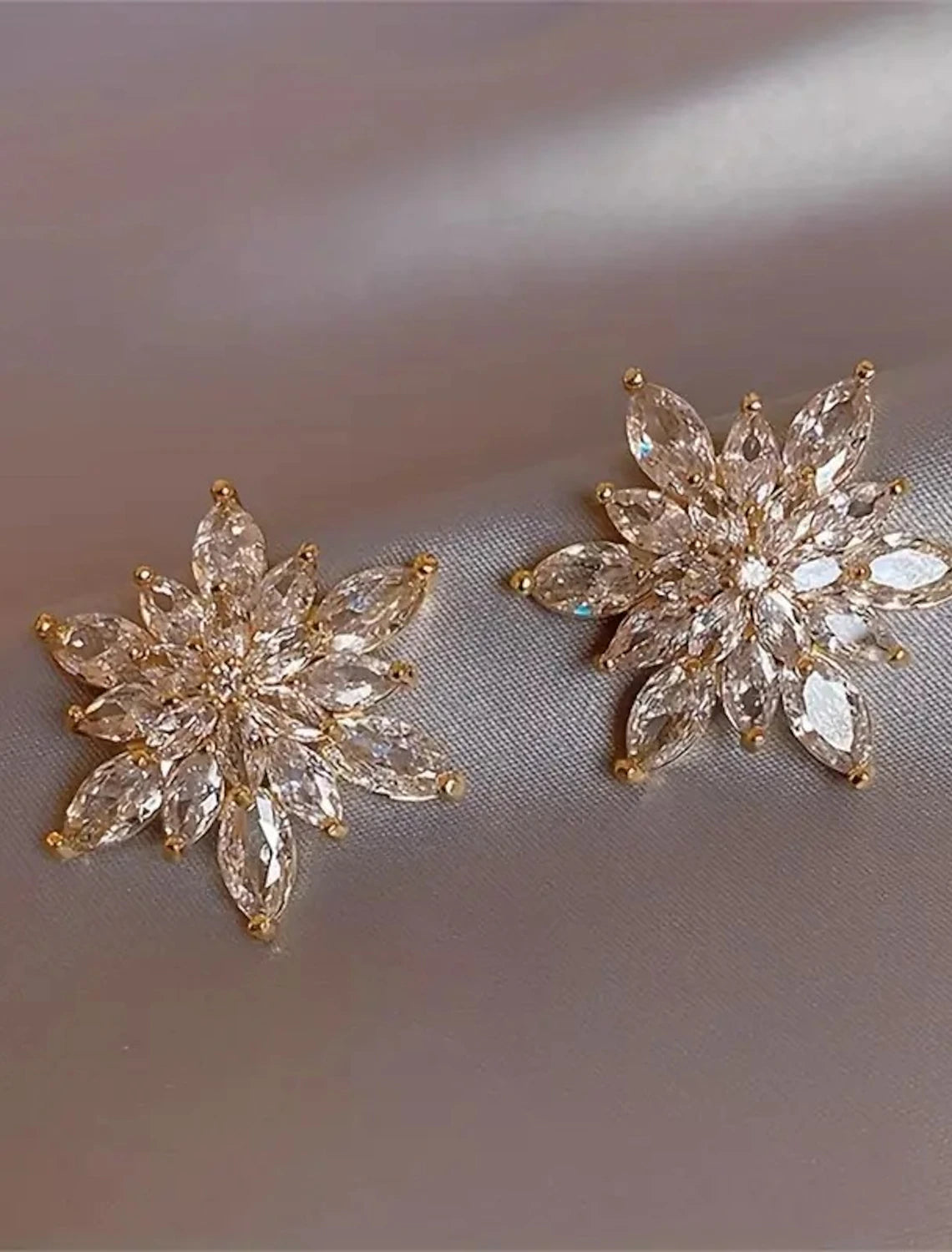 Golden flower stud earring with detailed petals.