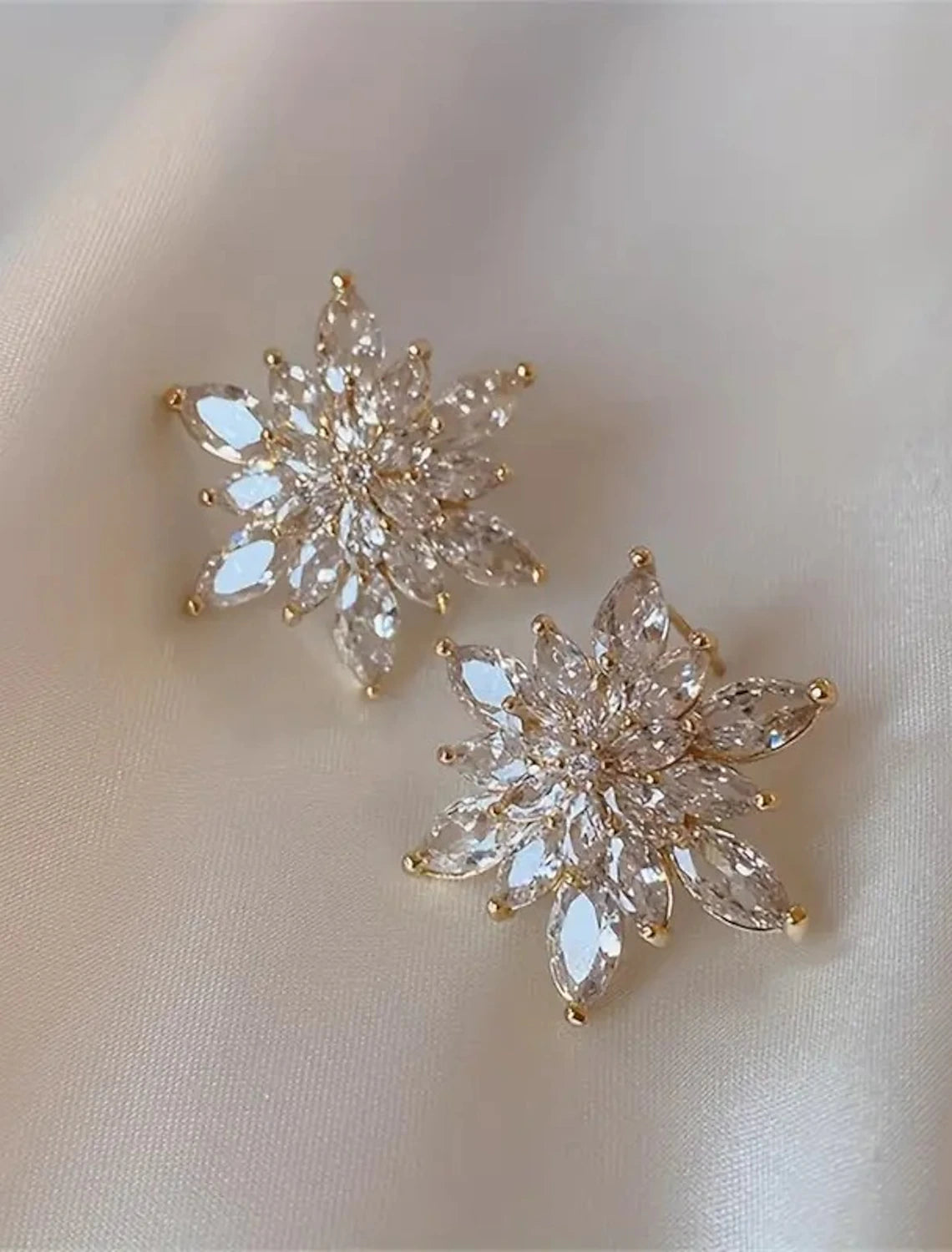 Golden flower stud earring from a side view.