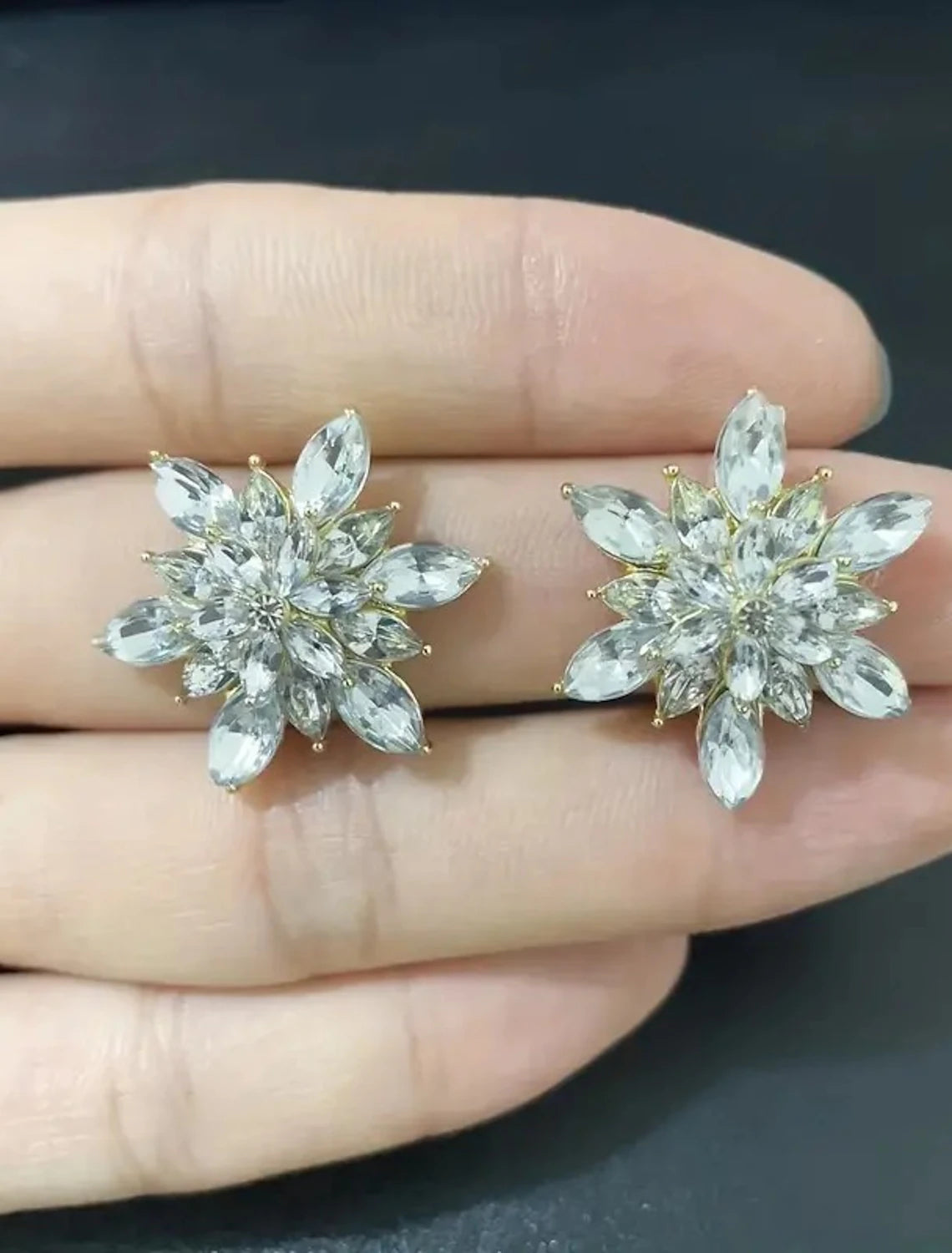 Golden flower stud earring showing its post.