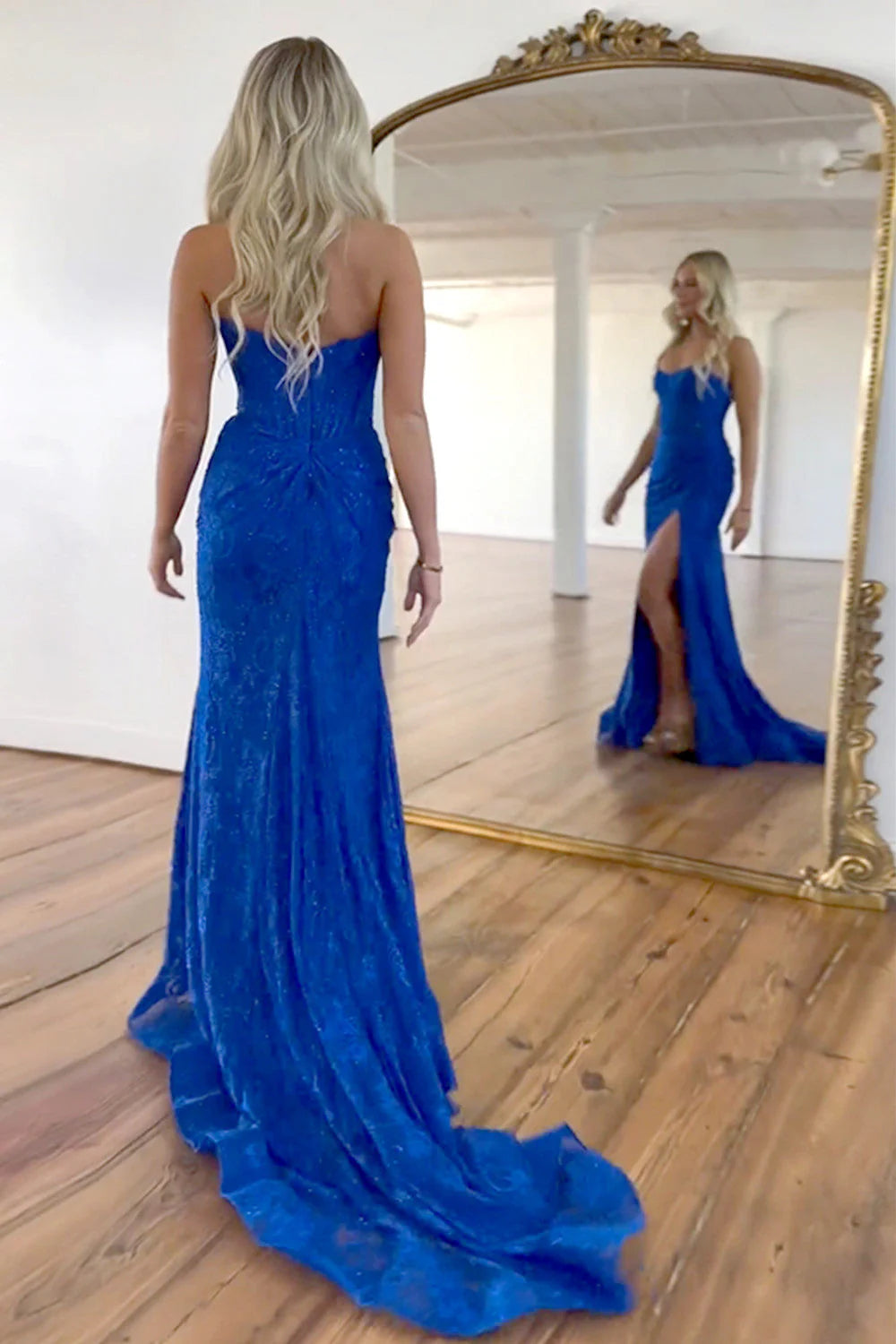 Detail of the high slit and elegant sweep train on the mermaid prom dress.