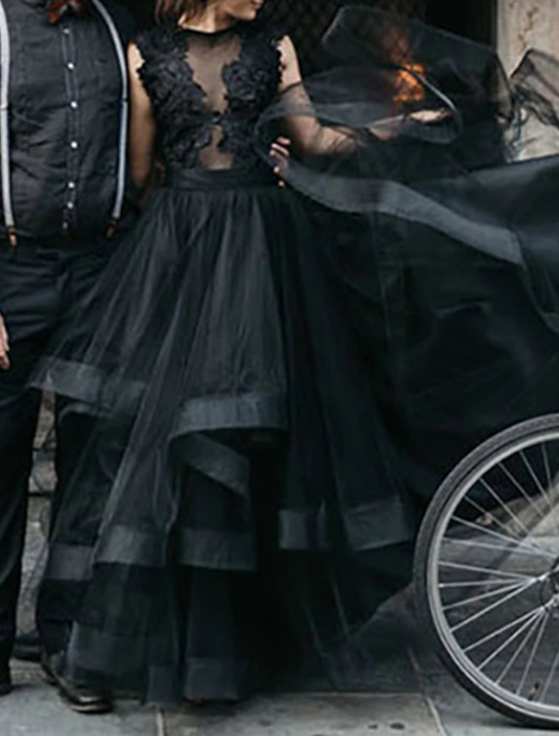 Side view of the black lace wedding gown with cascading ruffles and sweep train.