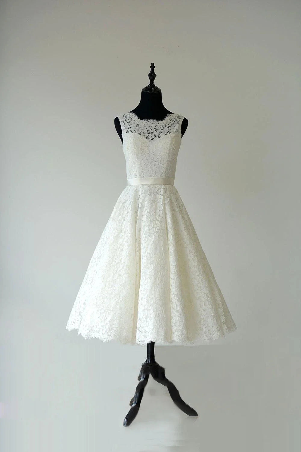 Elegant A-line tea length wedding dress with lace neckline and waistband.