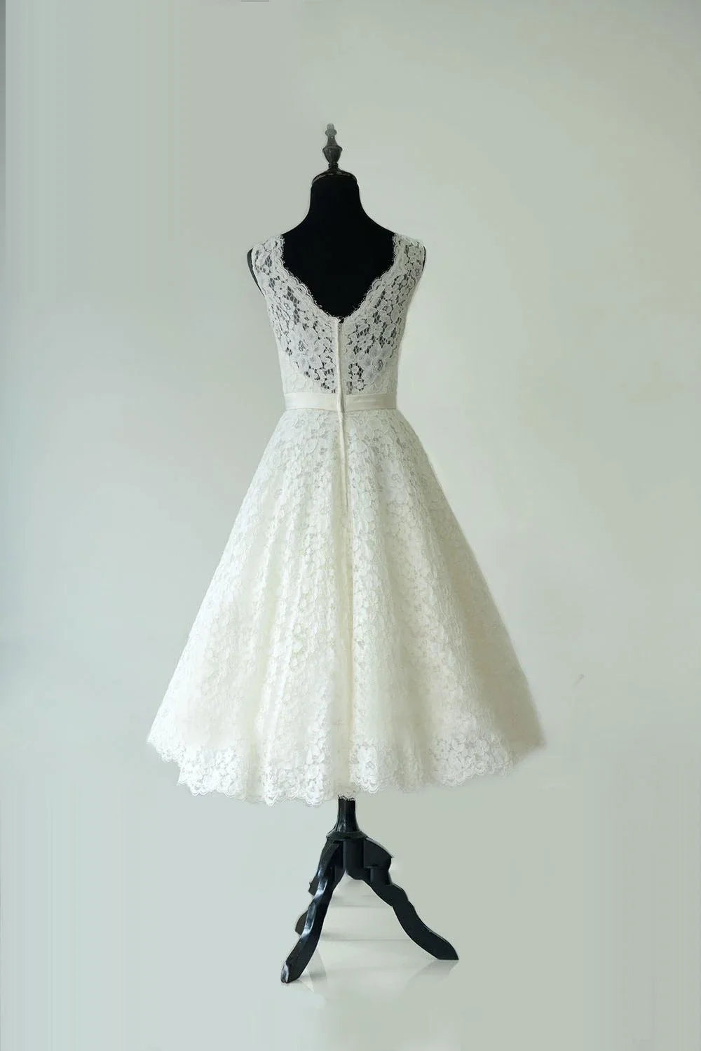 Sleeveless tea length bridal gown with lace detail, side view.