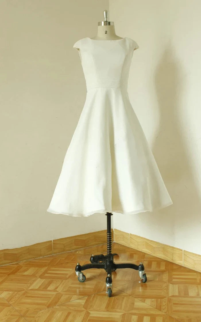 Back view of a graceful V-neck sleeveless tea-length satin wedding dress with open back.