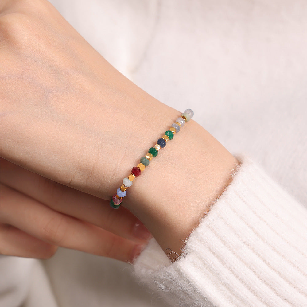 Close-up of multi-color tourmaline beads on a titanium steel necklace.