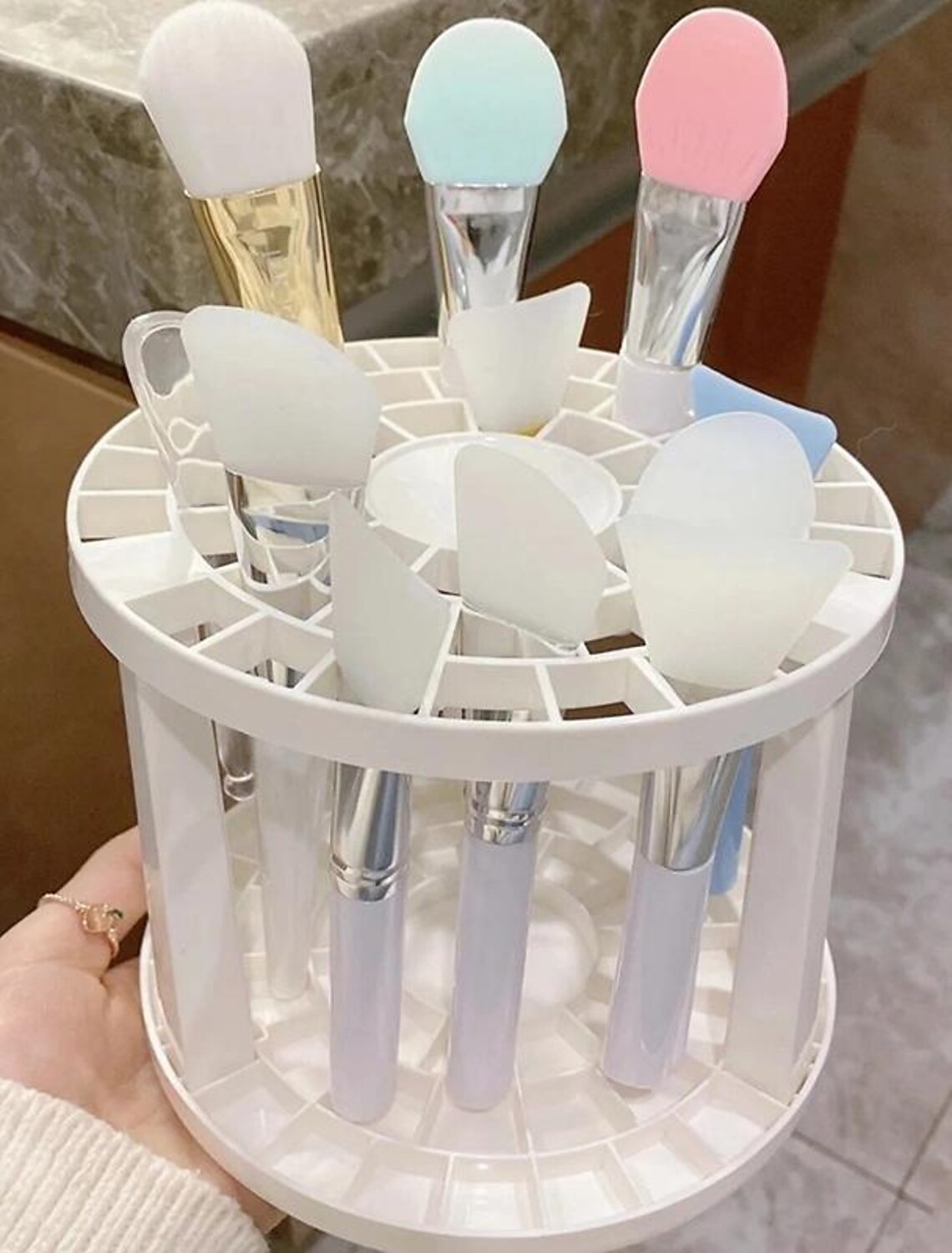 Makeup brush holder filled with various brushes and pens.