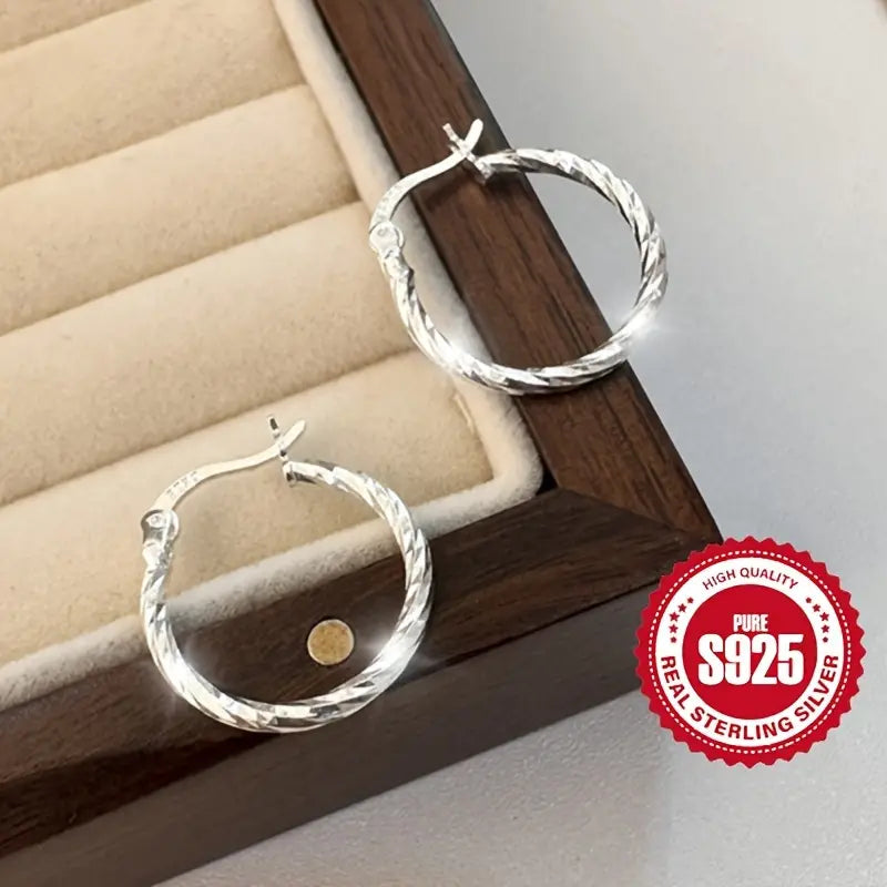 Pair of S925 Sterling Silver twisted hoop earrings on a white background.