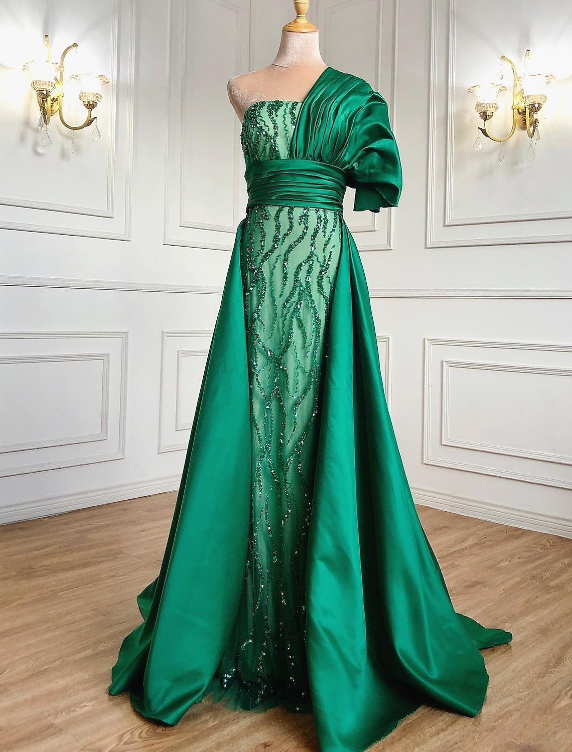 Model wearing a luxurious A-line one-shoulder charmeuse evening gown with ruched bodice and sparkling crystal details.