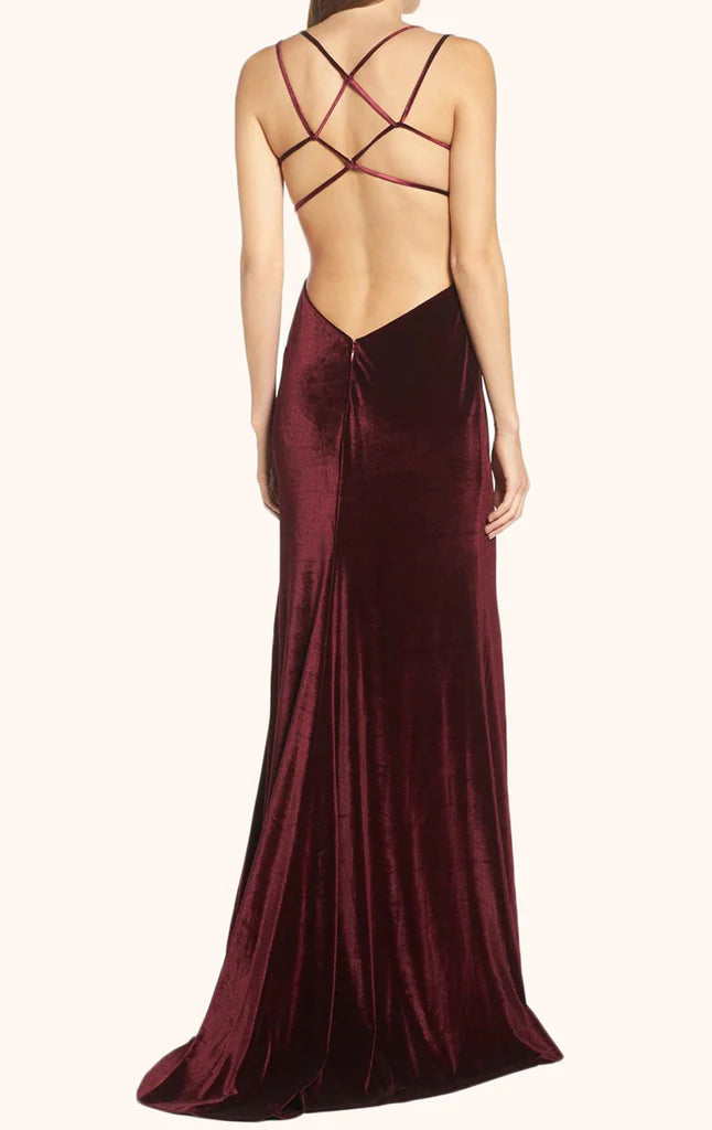 Model showcasing the backless design of a velvet formal gown.