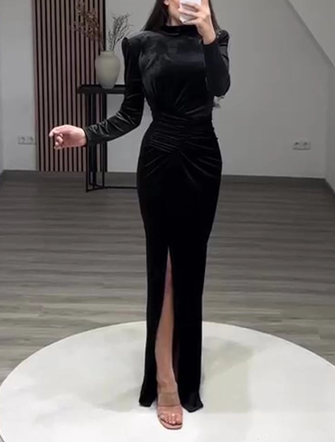 Close-up of the velvet fabric and high neck detail of the black gown.