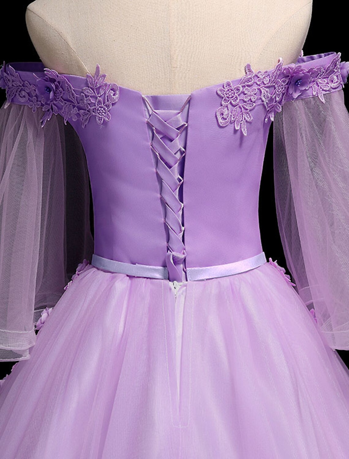 Model showcasing the flowing tulle skirt and ribbon embroidery of the ball gown.