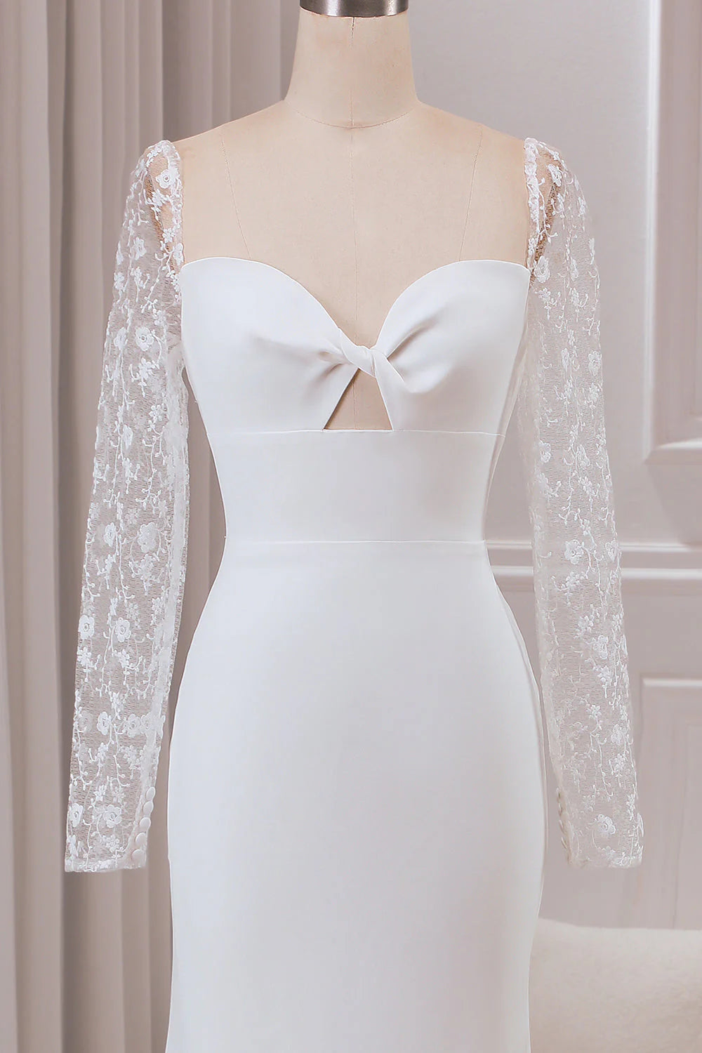 Close-up of the lace long sleeves and sweetheart neckline on the ivory wedding gown.