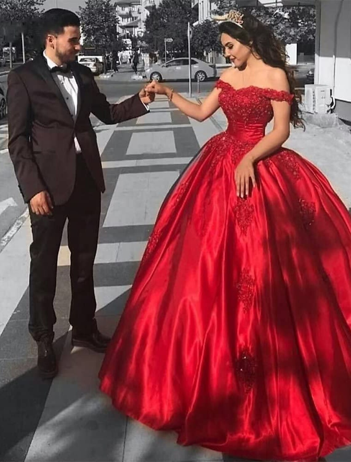 Full view of an elegant off-shoulder ball gown with lace appliques and a chapel train.