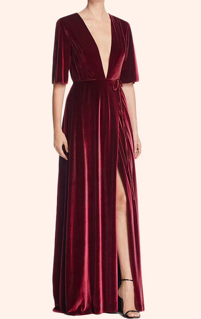 Woman wearing a luxurious velvet deep V-neck maxi evening gown.