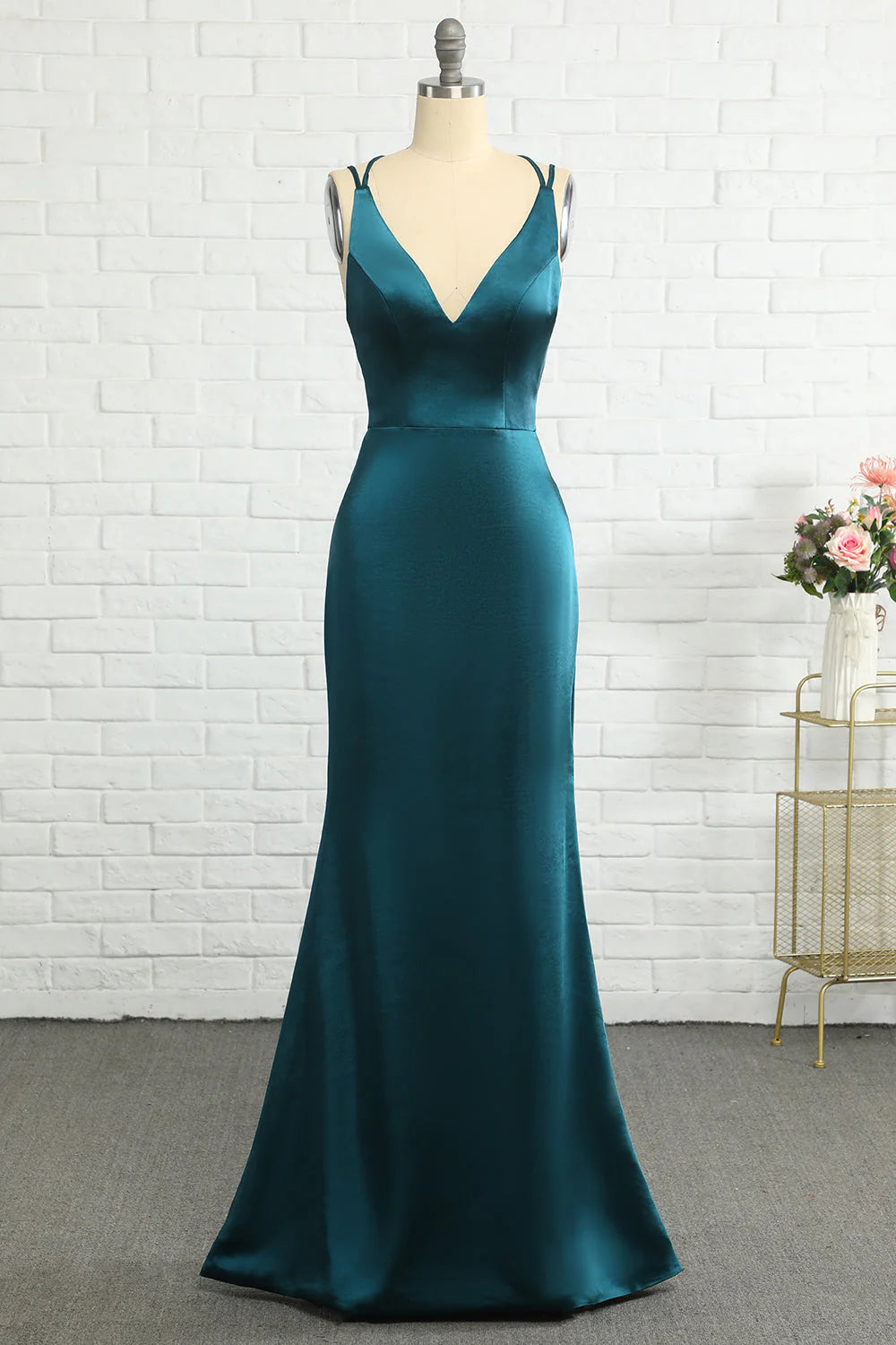 Woman wearing a dark, shimmering mermaid-style backless long prom dress.