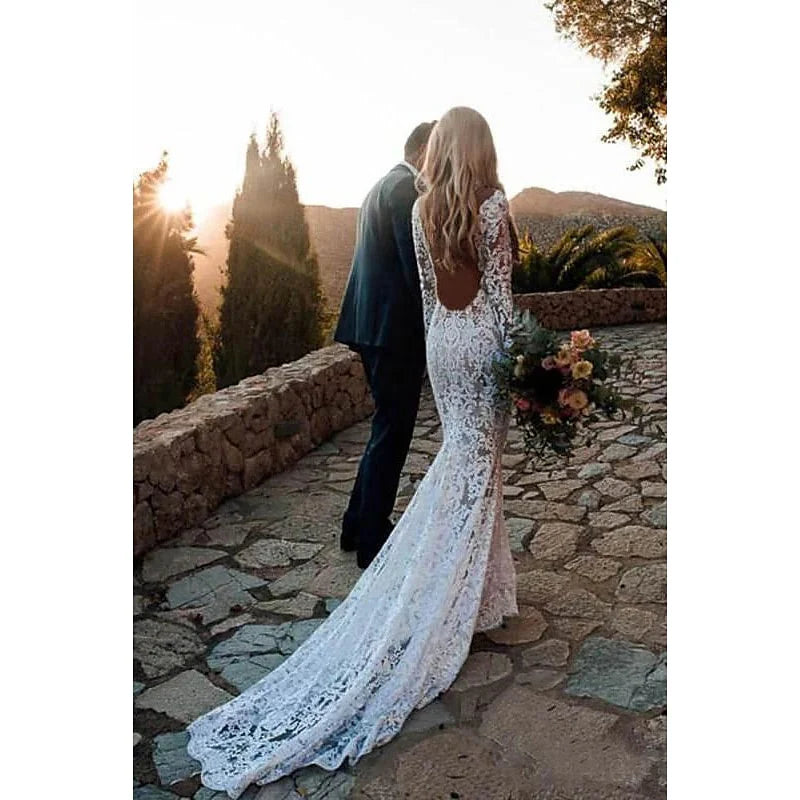 Close-up of the V-neckline and delicate appliques on a long sleeve mermaid wedding dress.