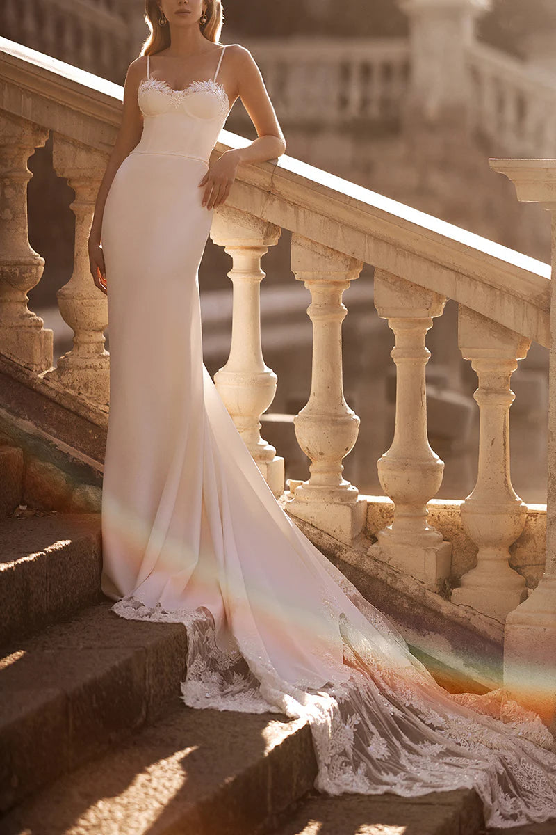 Elegant mermaid wedding dress with spaghetti straps and lace appliques.