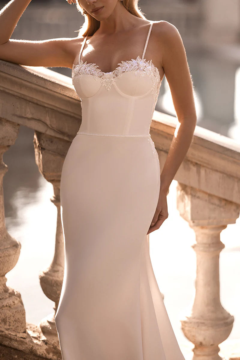 Close-up of intricate lace appliques on the bodice of a wedding dress.