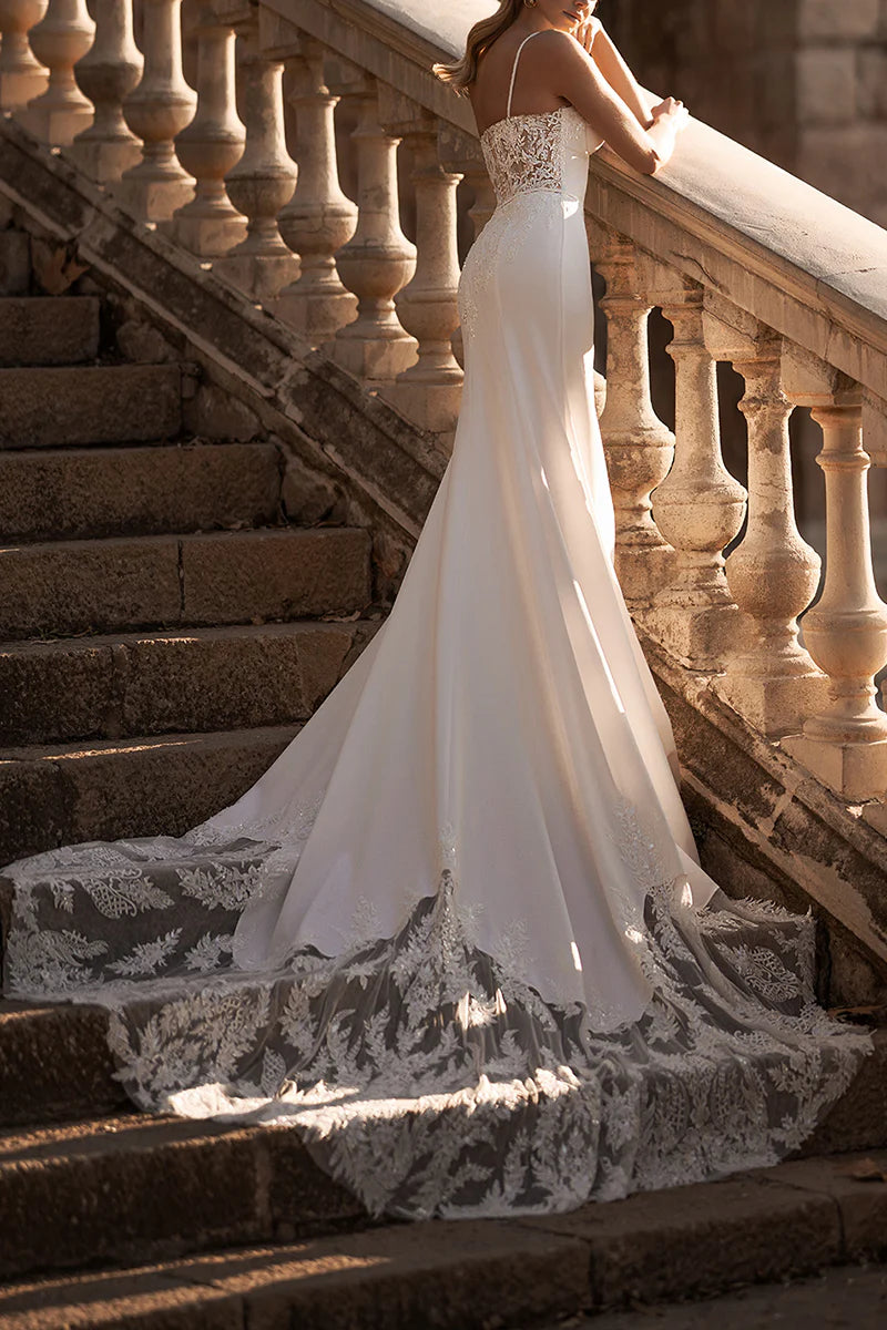 Side profile of a mermaid wedding dress with spaghetti straps and a court train.