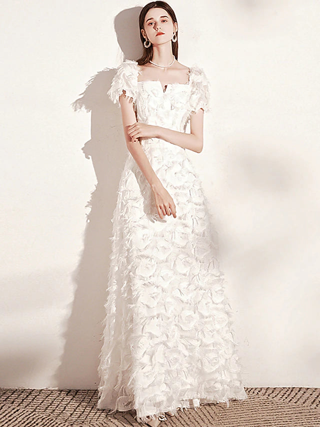 Woman wearing a minimalist A-line evening gown with feather detail.