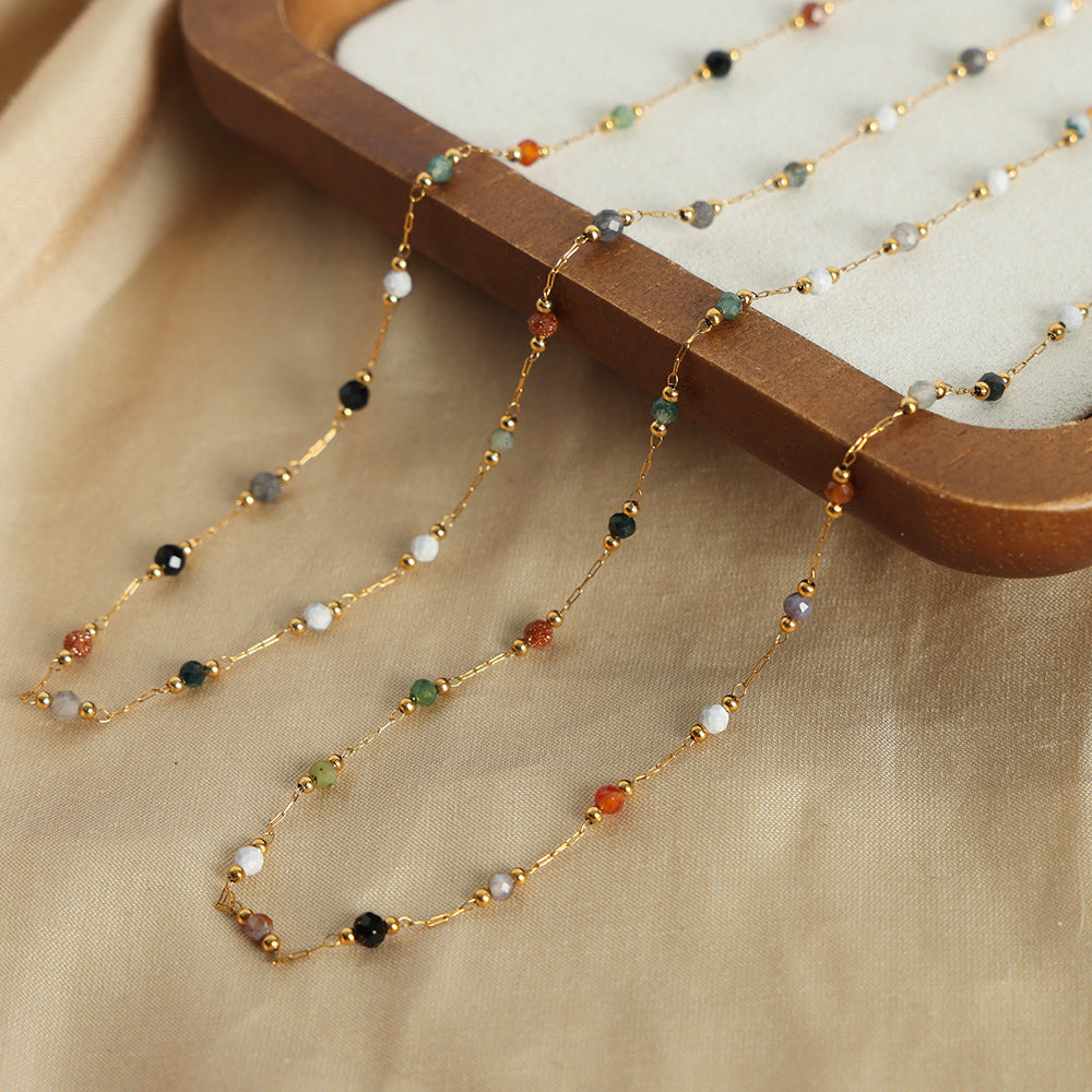 Close-up of natural stone beads on a titanium steel bracelet.