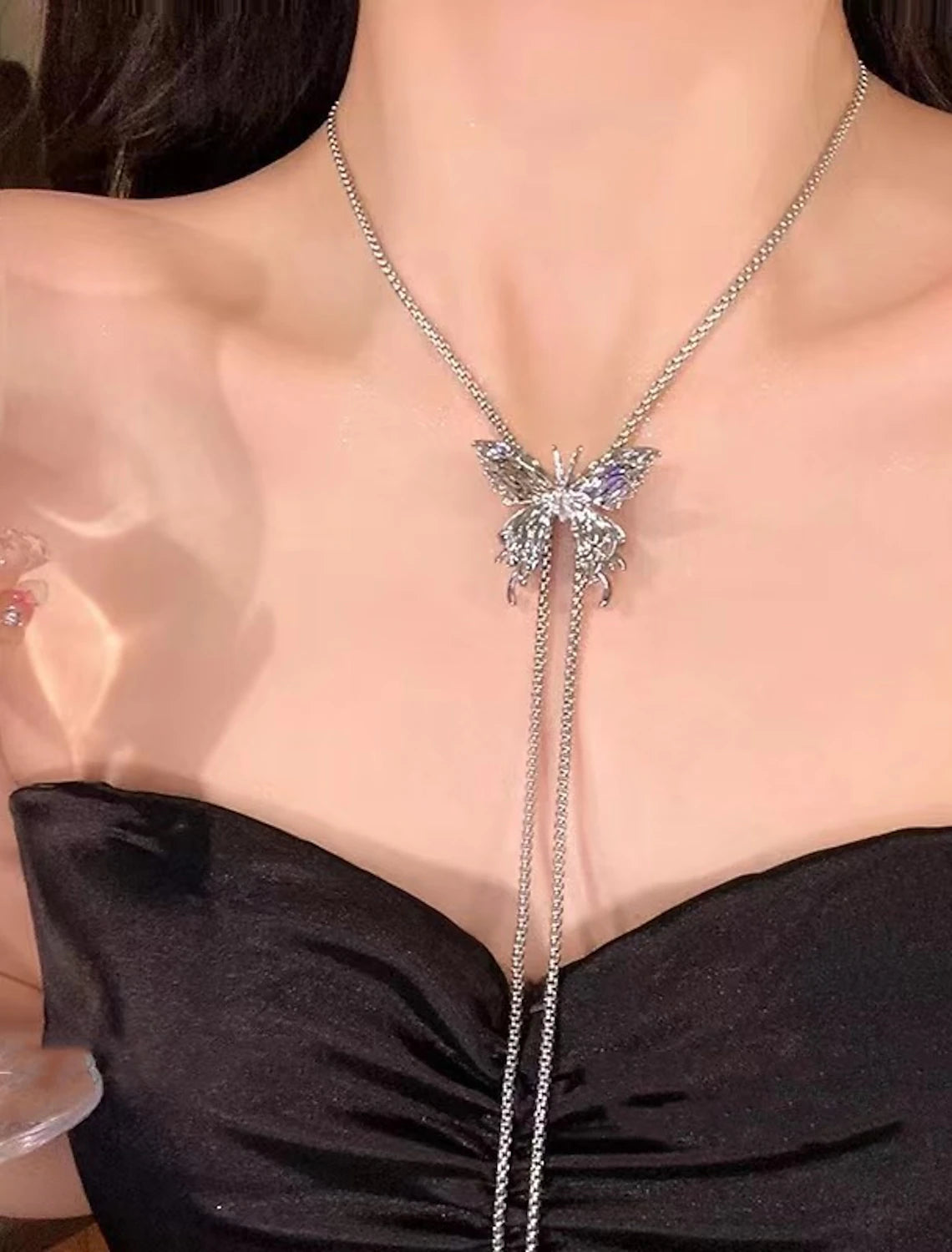 Women wearing a modern chrome tassel butterfly geometric necklace.