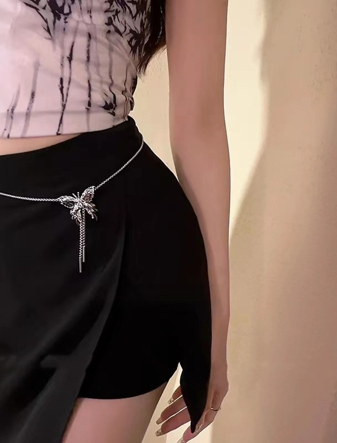 Close-up of chrome tassel butterfly geometric necklace.