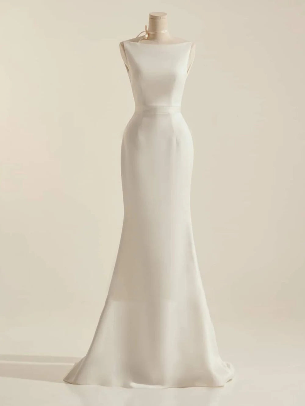 Elegant mermaid wedding dress with a V-neckline and delicate bow detail, shown from the front.