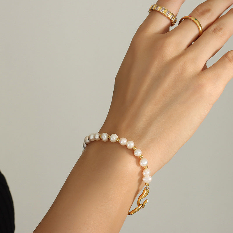 Women's titanium steel bracelet featuring lustrous freshwater pearls.