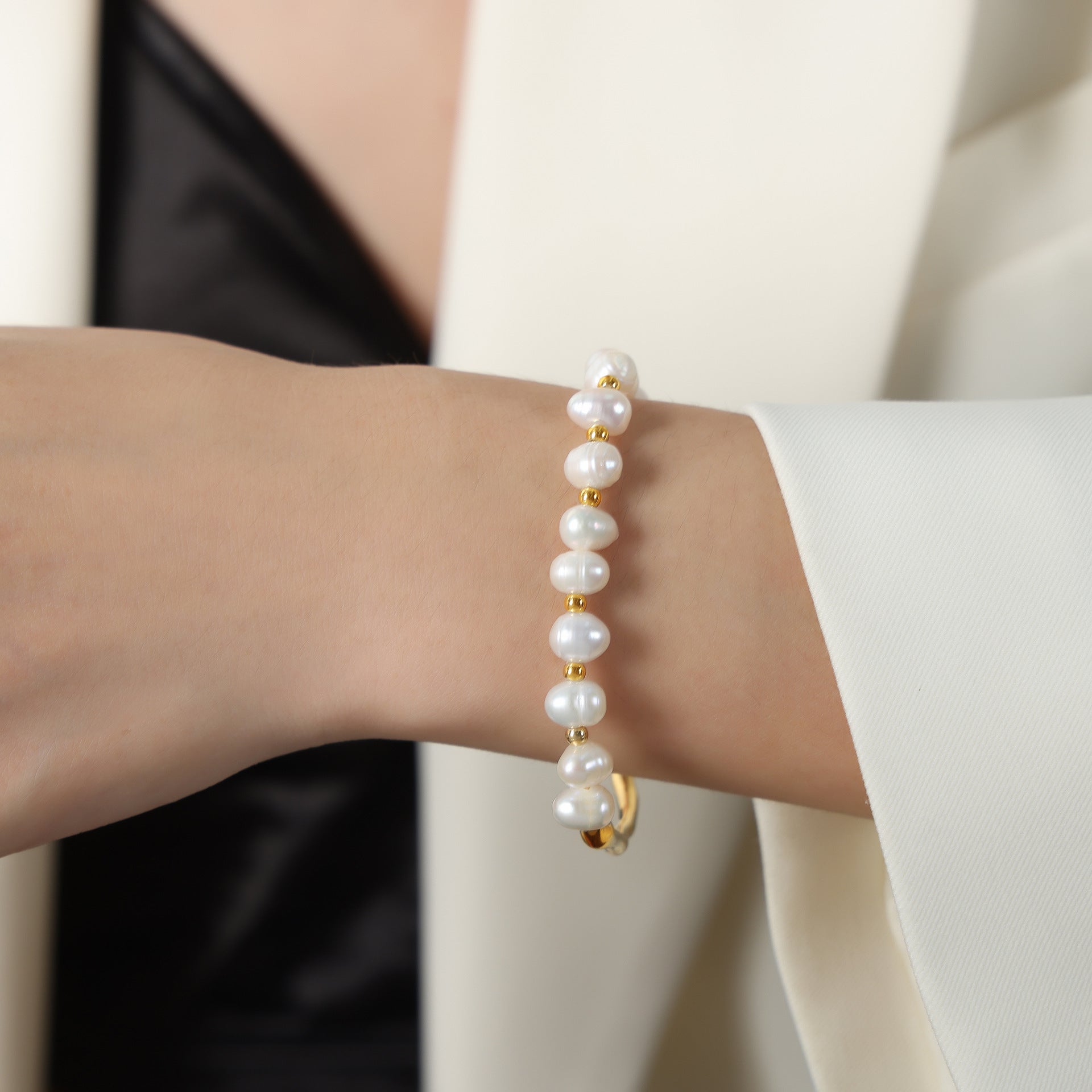 Detailed view of the clasp and chain on the pearl bracelet.