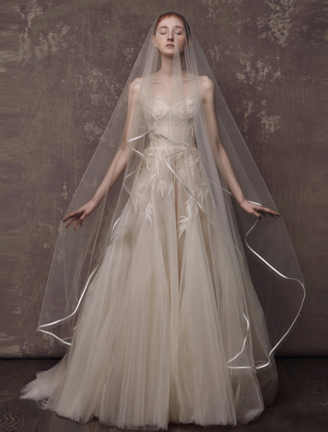 Close-up of a bride wearing an elegant one-tier chapel wedding veil, highlighting the soft tulle fabric.