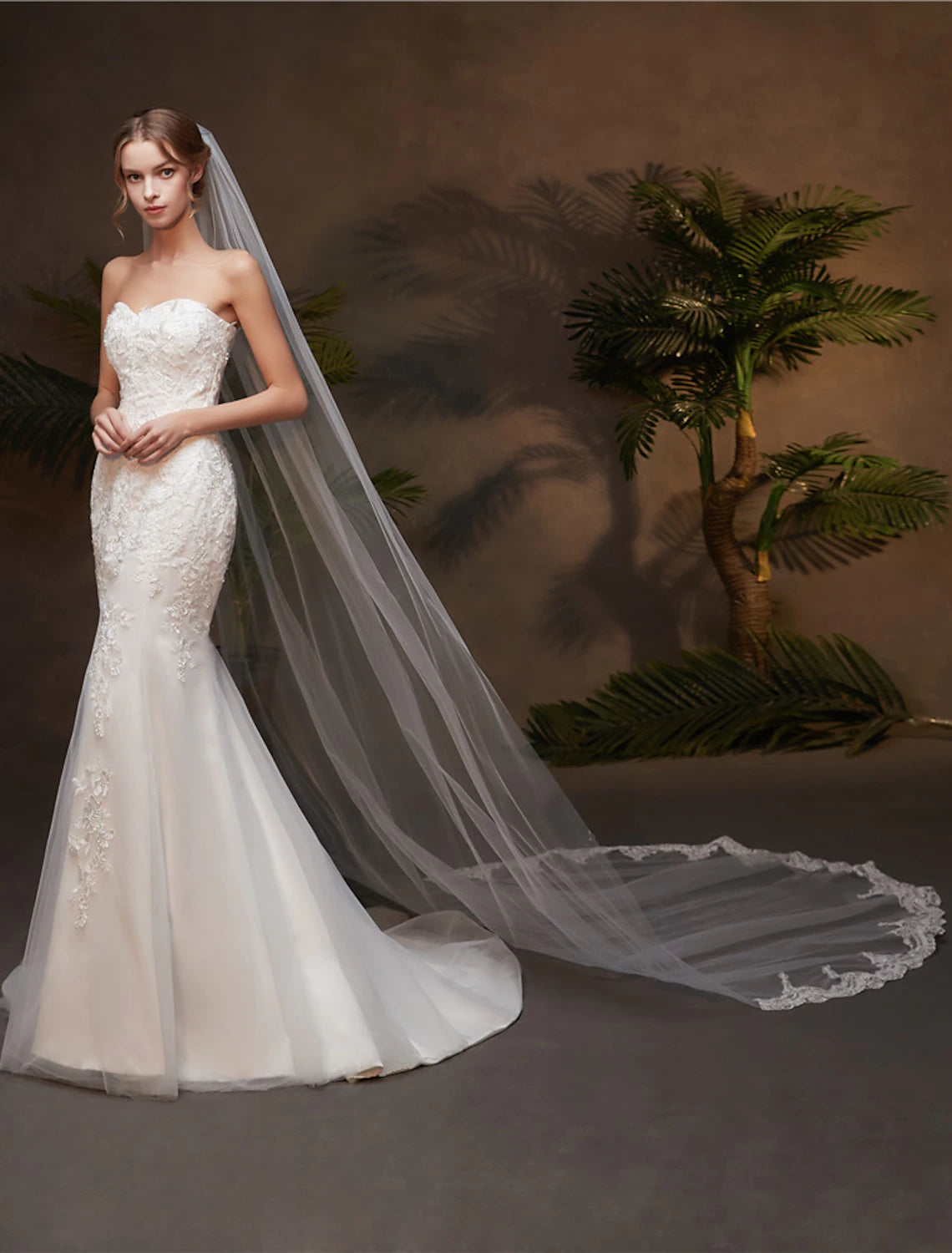 Bride wearing a one-tier chapel wedding veil with lace appliques.