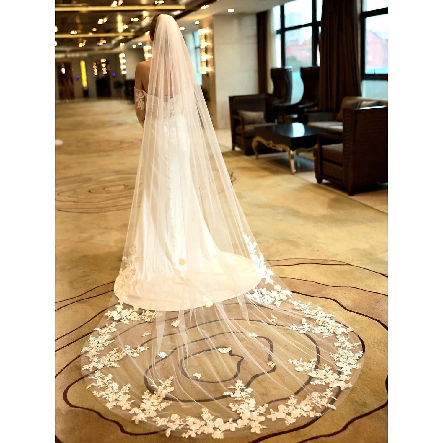 Bride wearing a long embroidered tulle veil.