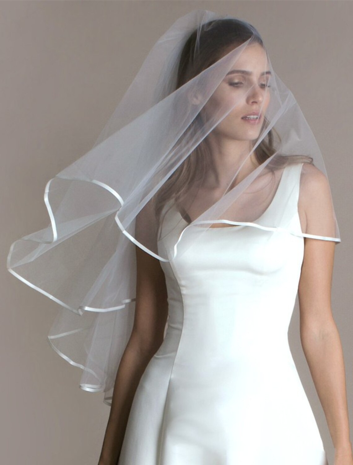 Bride wearing a simple one-tier tulle wedding veil blusher.