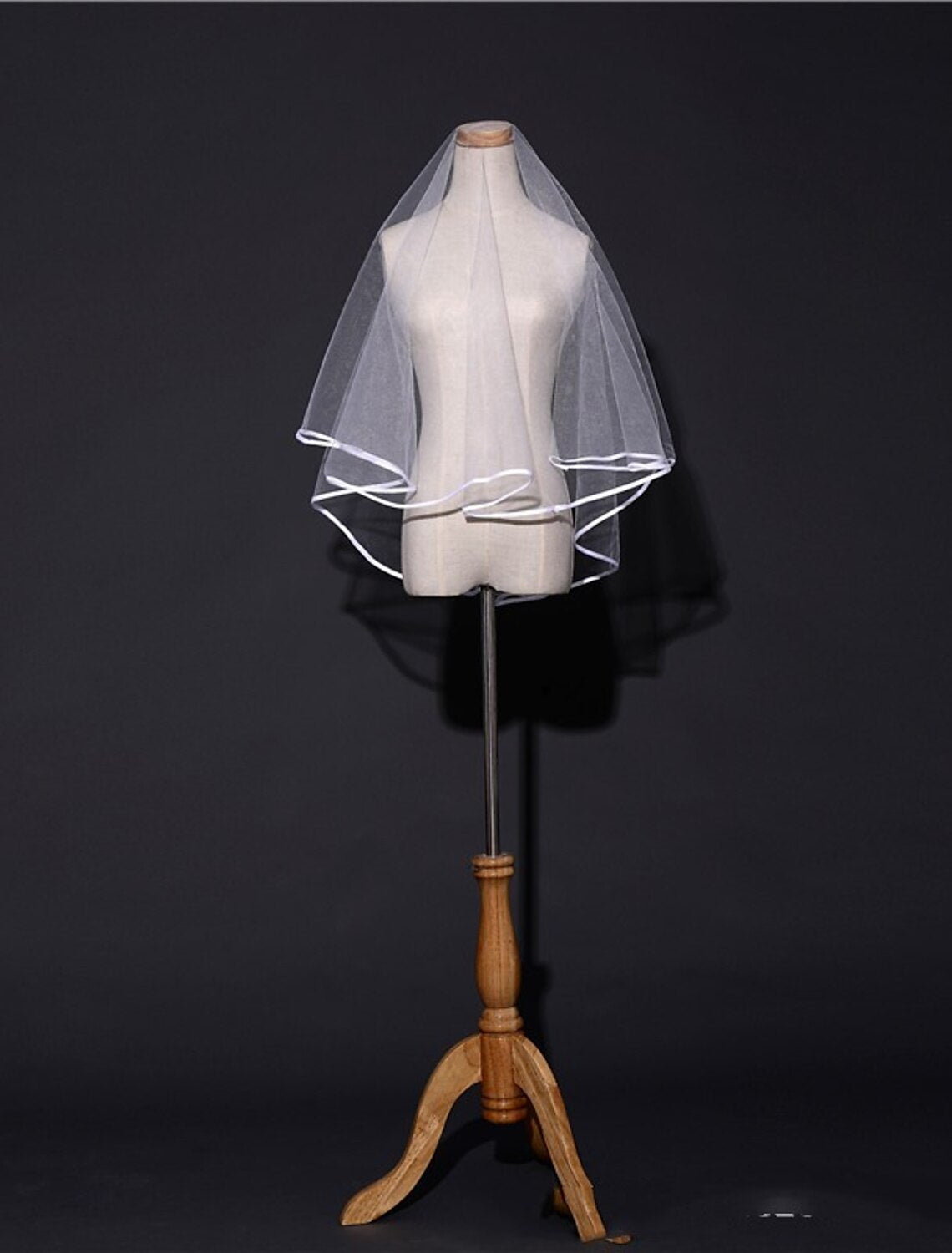 Close-up of a bride with a delicate one-tier blusher veil.