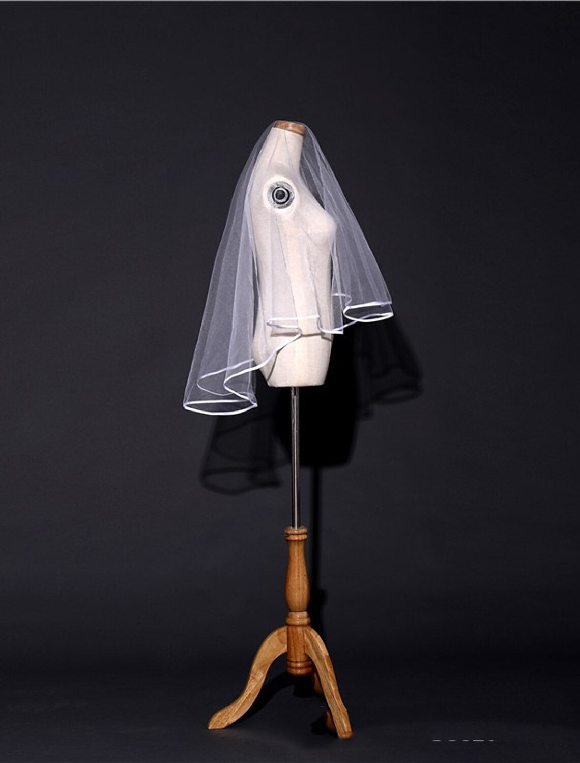 Bride with a pure color tulle veil flowing behind her.