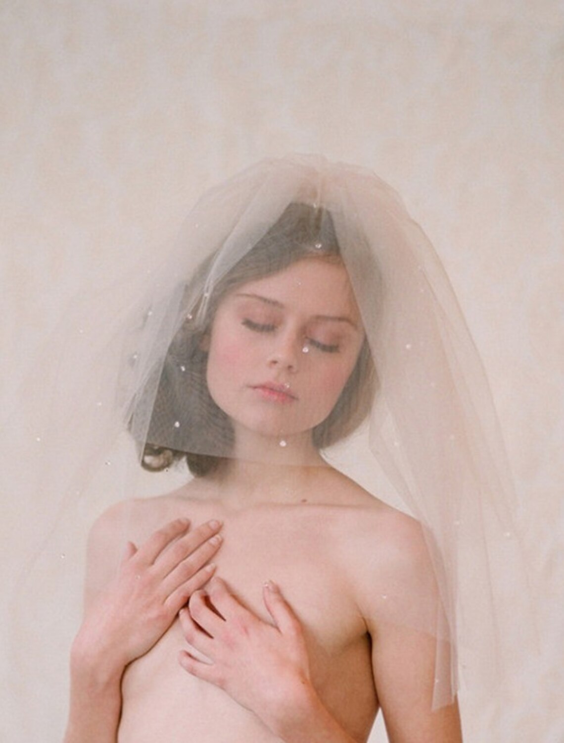 Side profile of a bride, highlighting the delicate one-tier wedding veil with its shimmering decorations.