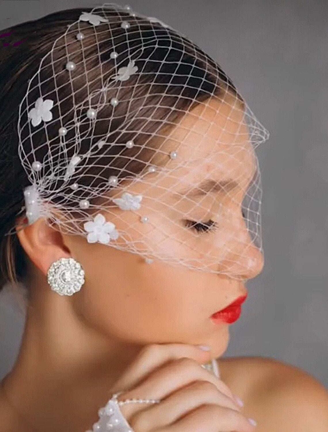 Back view of a bride wearing a wedding veil adorned with faux pearls.