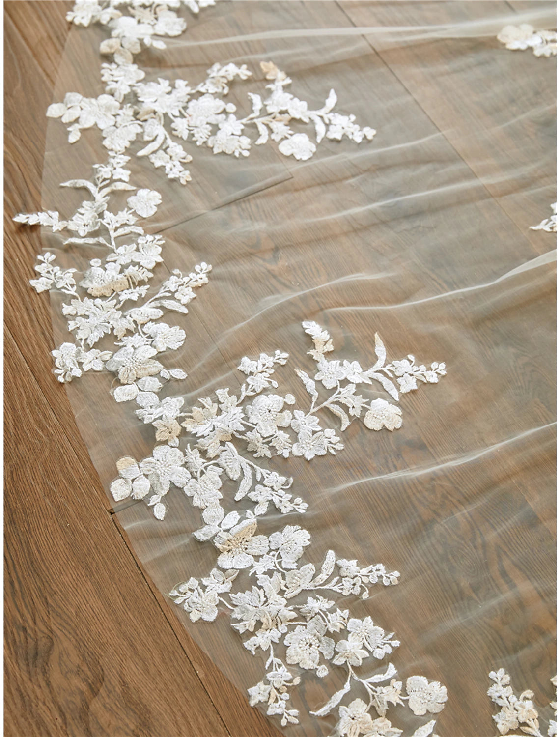 Bride posing gracefully, highlighting the full length of the embroidered cathedral veil.