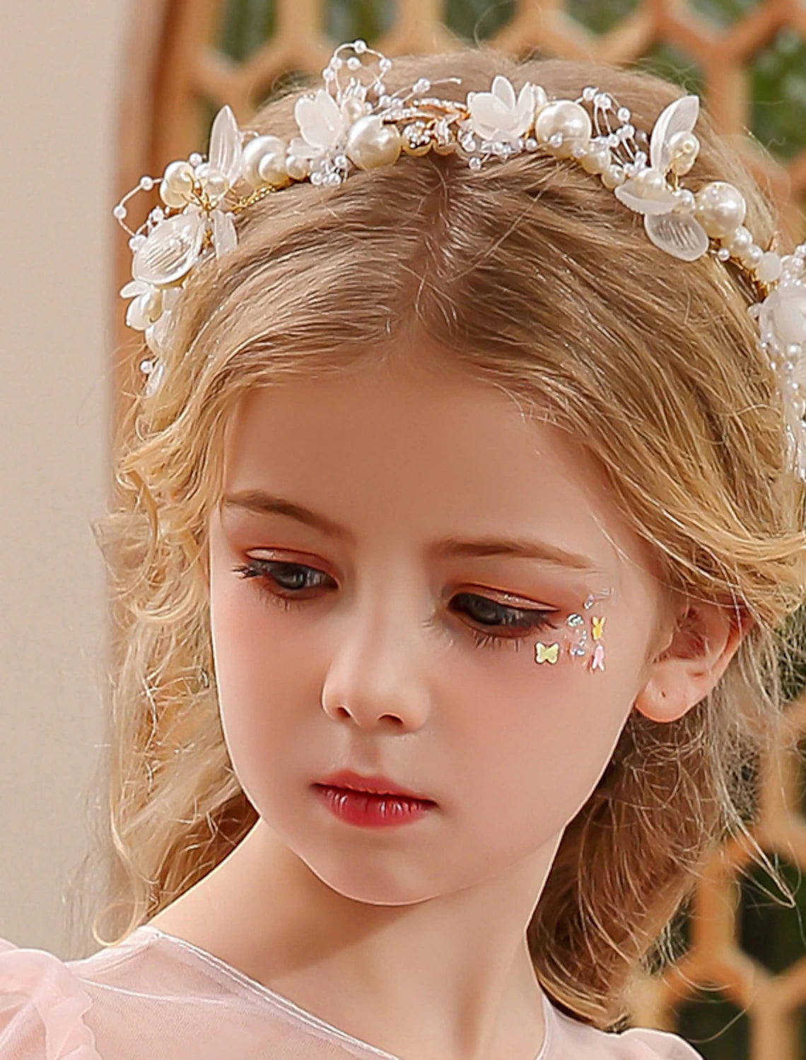 Side view of a pearl and rhinestone tiara headband on a white background.