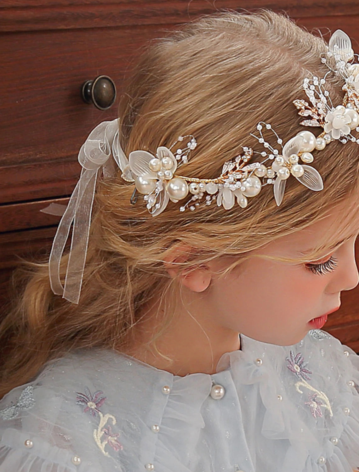 Front view of a pearl and rhinestone tiara headband, highlighting its curved shape.