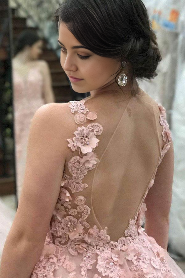 Back view of a pink A-line prom dress, highlighting the open back and appliques.