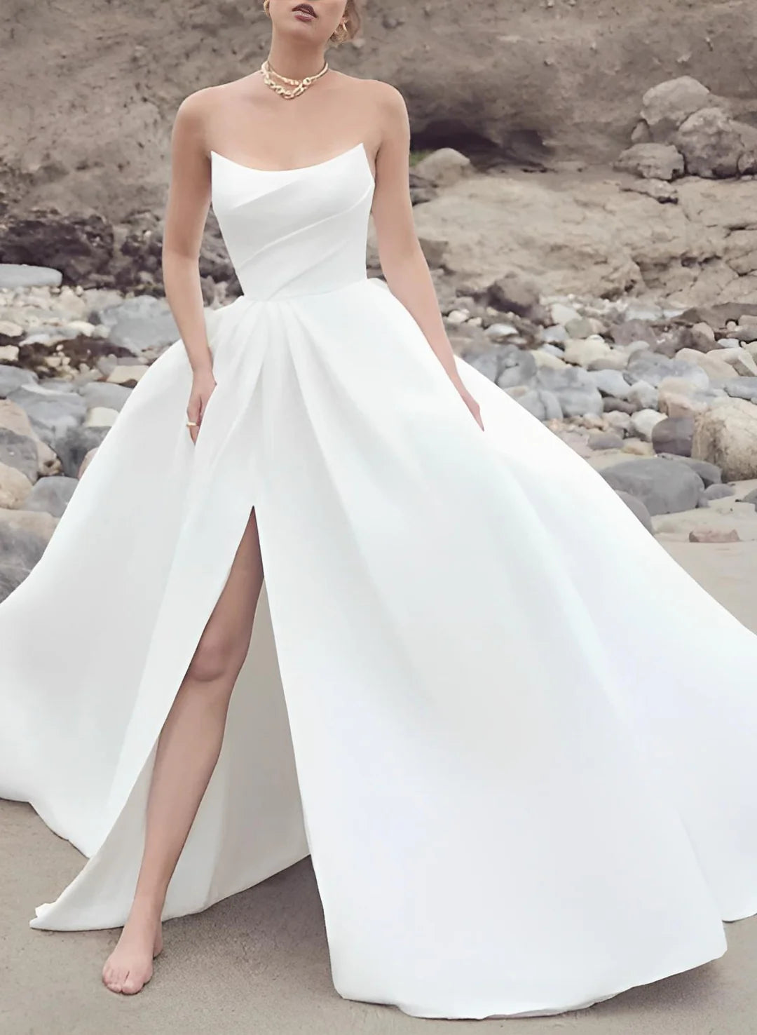 Plus size model in a white strapless A-line wedding dress, front view.