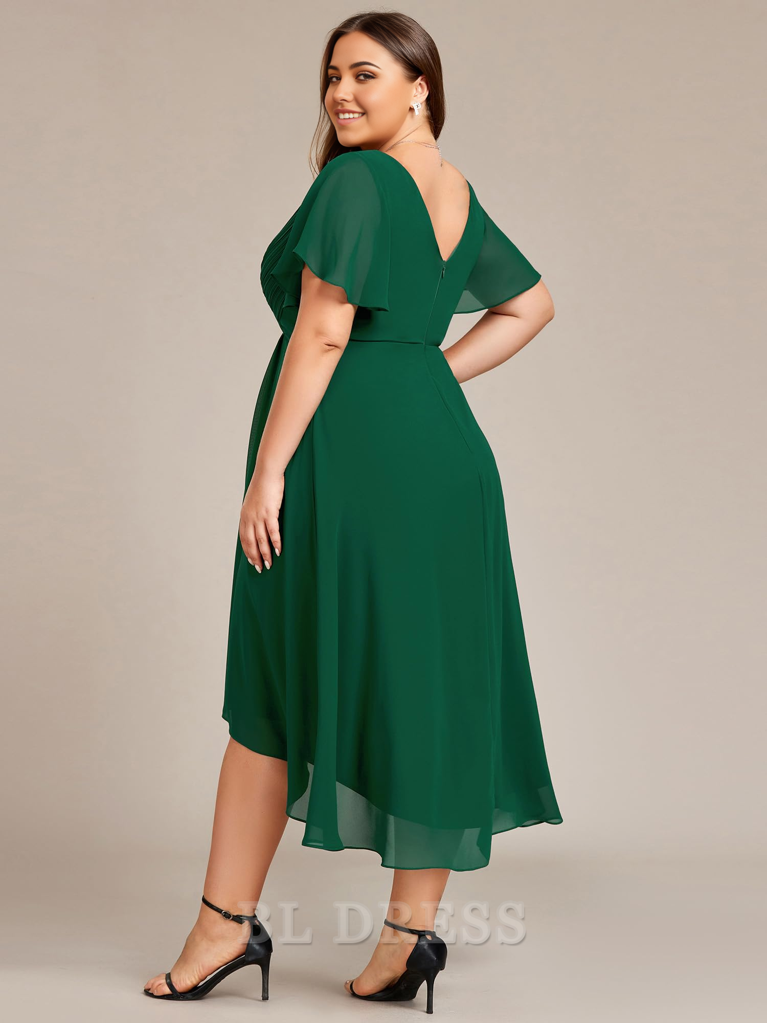 Plus size model posing in an A-line V-neck chiffon knee-length dress, showing the back detail.