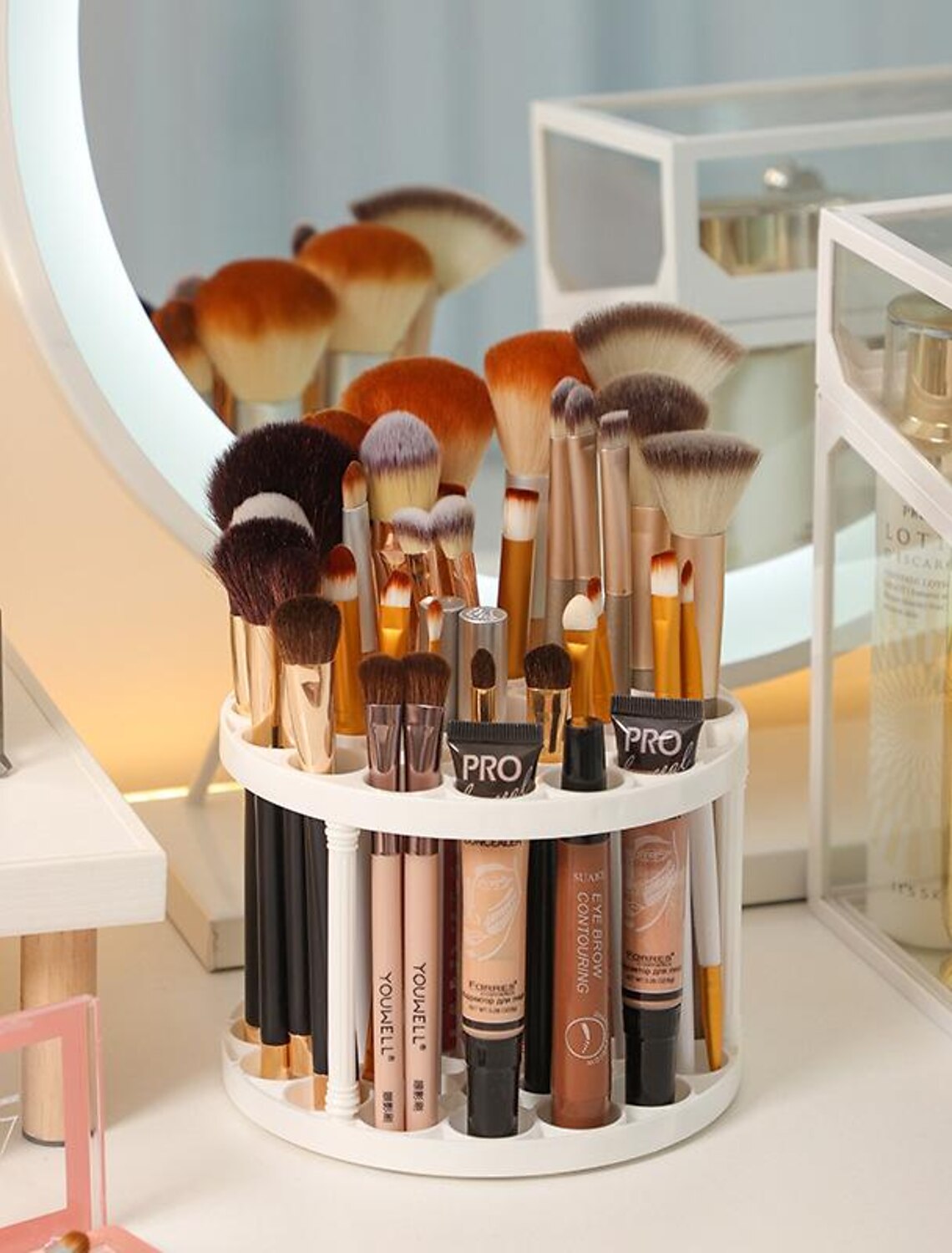 Clear plastic makeup brush drying rack with various brushes inside.