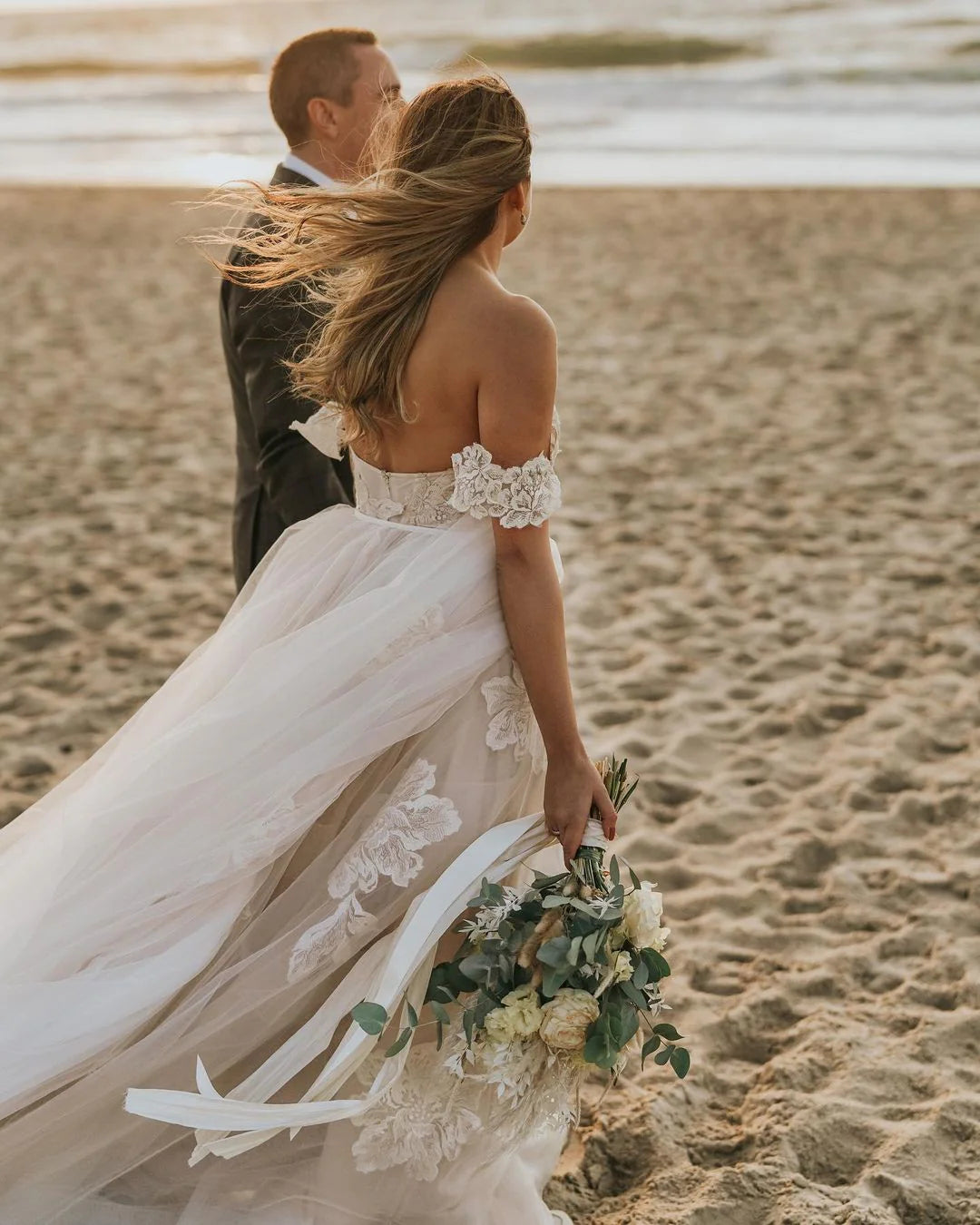 Back view of the off-shoulder backless wedding dress with delicate lace details.