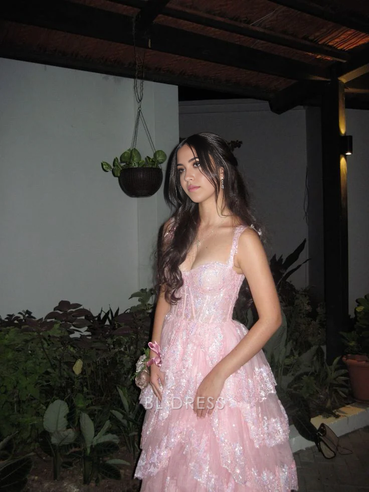 Back view of blush pink A-line gown showing lace-up corset and ruffled tulle skirt.