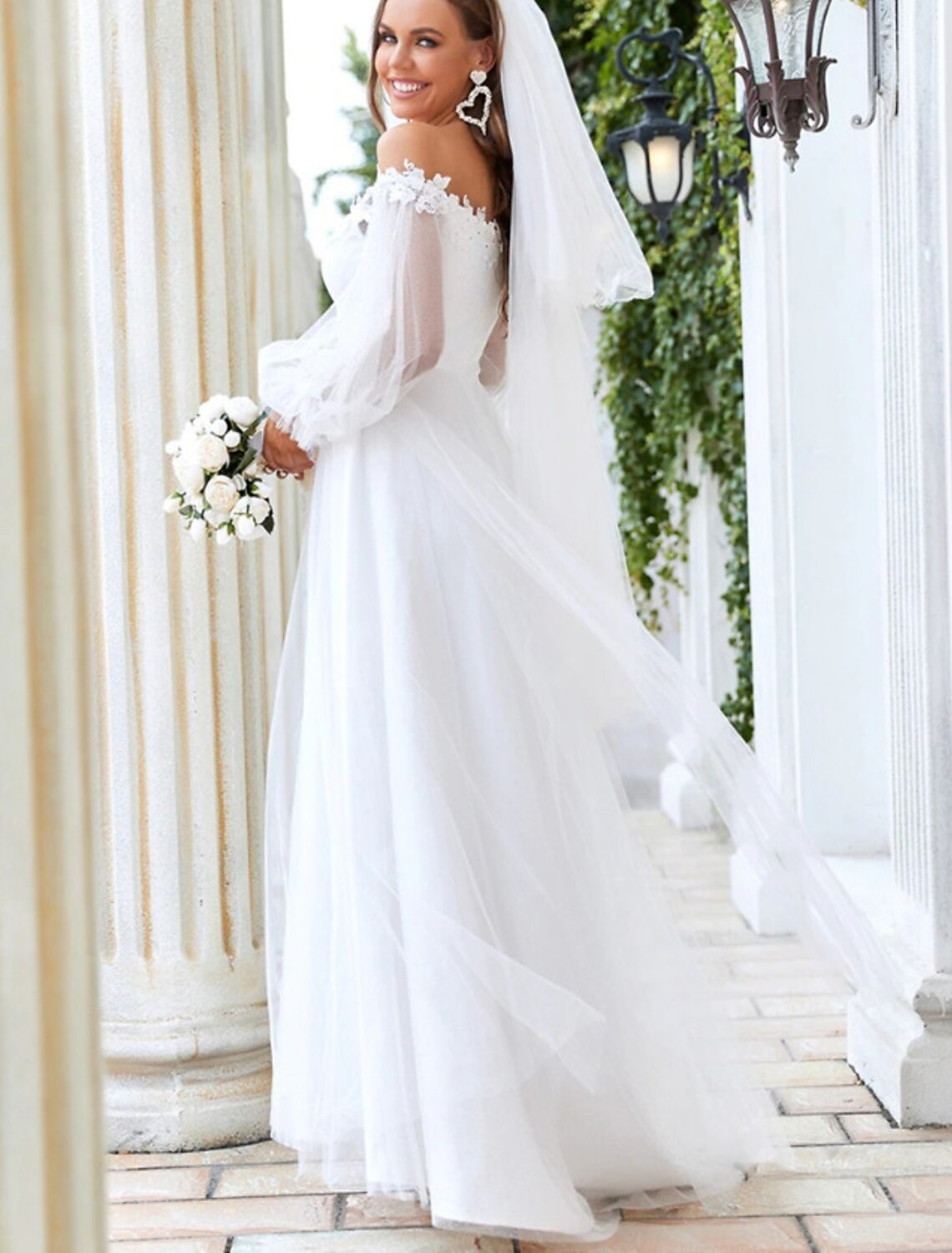 A-Line off-shoulder long sleeve tulle wedding dress with lace appliques.