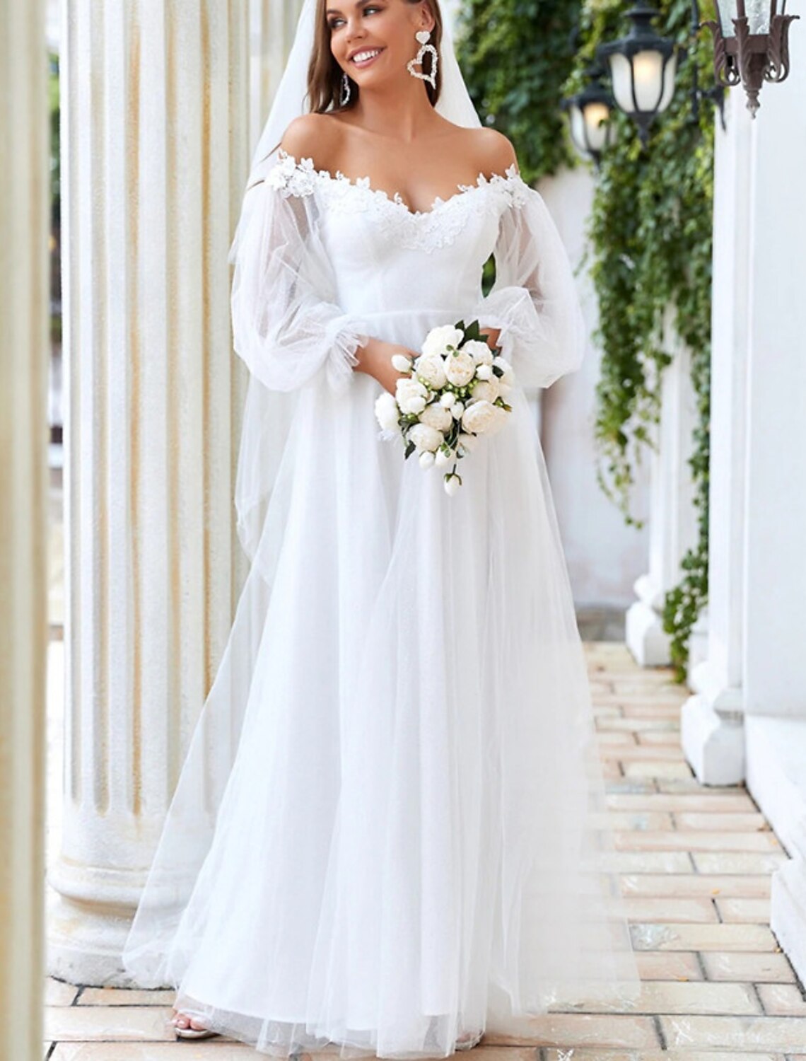 Elegant floor-length bridal gown featuring off-shoulder neckline and lace details.