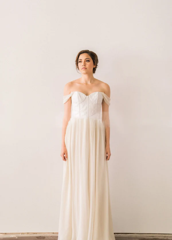 Close-up of lace bodice and off-shoulder V-neck on wedding dress.